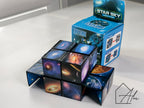 Two cubes transformed into 3D star shapes, one with colourful nebula art, one with blue starfield, box showing transformation instructions in the centre
