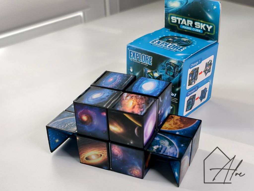 Two cubes transformed into 3D star shapes, one with colourful nebula art, one with blue starfield, box showing transformation instructions in the centre