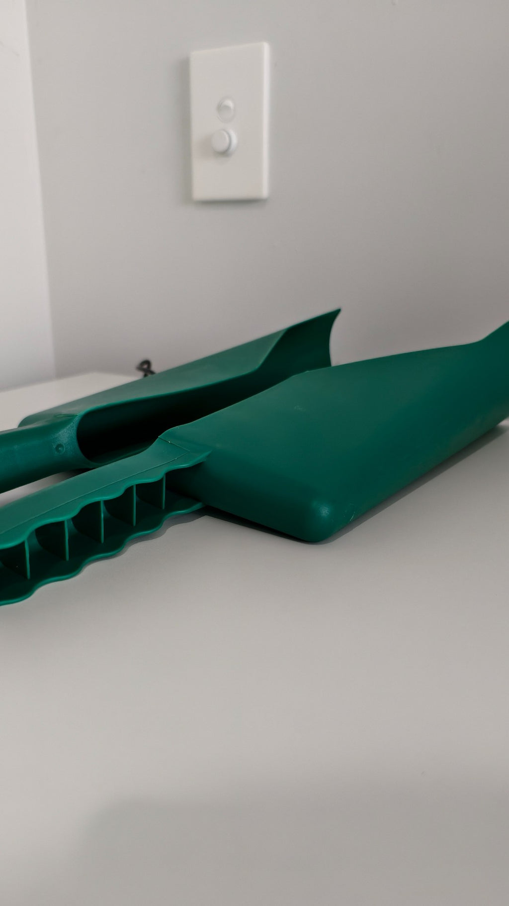 Plastic gutter scoop in use – clearing leaves from roof gutter