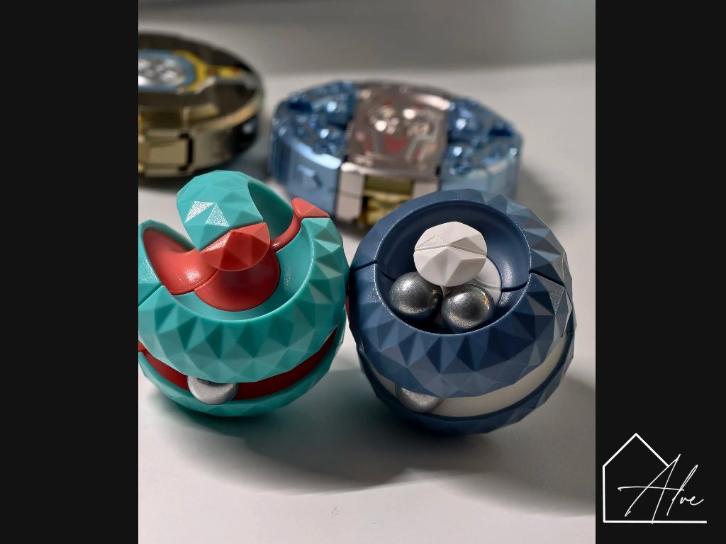Teal and dark blue sphere fidget balls side by side, both showing faceted panels and steel beads