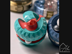 Close-up of the teal and red sphere fidget ball on a light surface