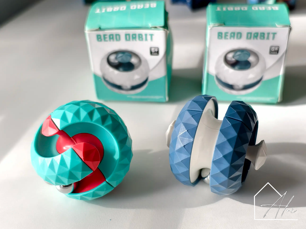 Teal, red and blue sphere fidget balls together showing both colourways
