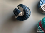 Blue sphere fidget ball with the two halves twisted apart, steel bead visible