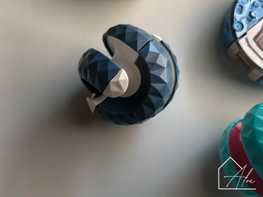 Blue sphere fidget ball with the two halves twisted apart, steel bead visible